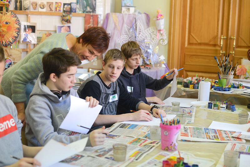 На мастер-классе по рисунку гуашью. Детям помогает волонтер музея Наталья Есикова
